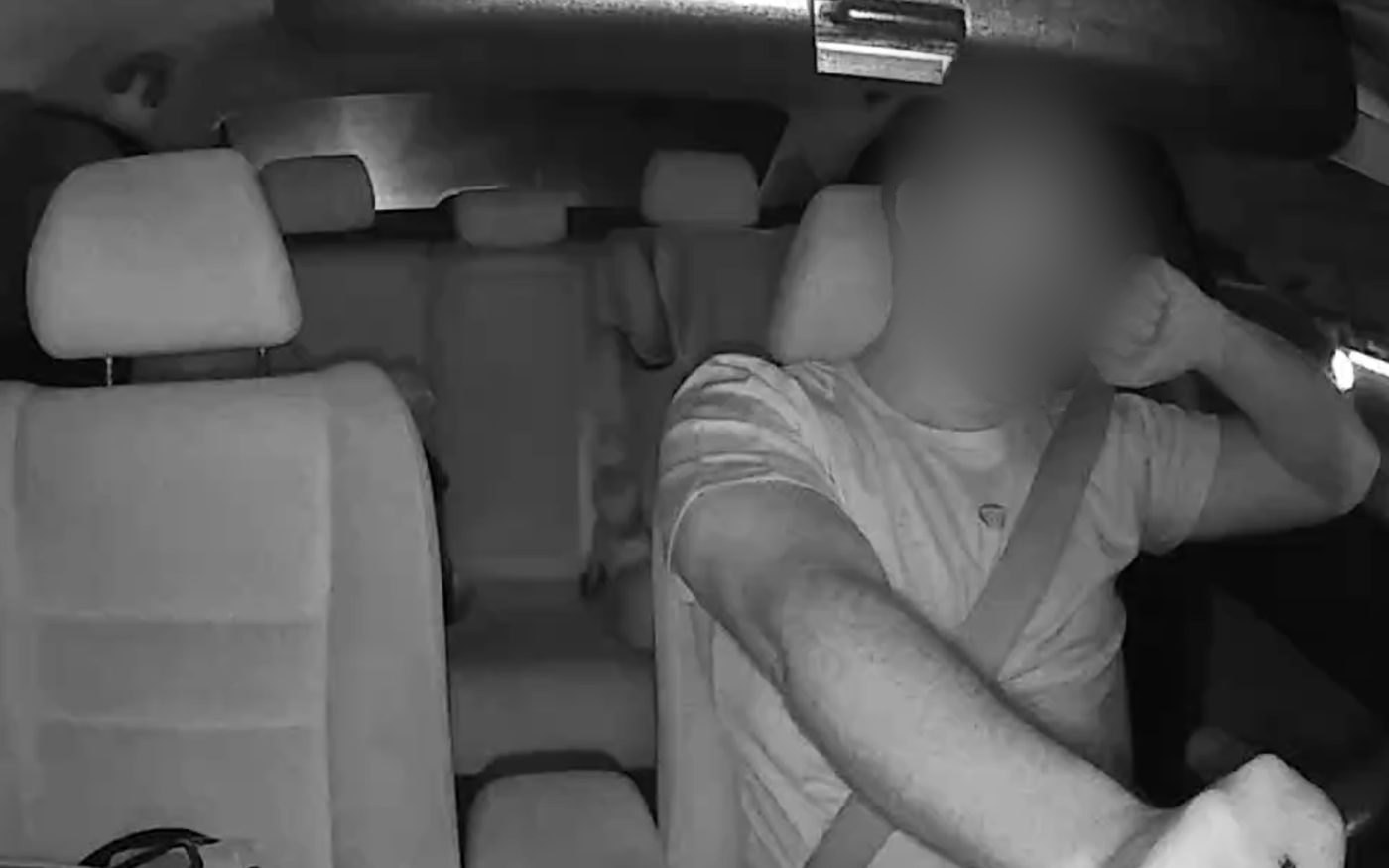 A cabin-facing camera view of a driver, in infrared