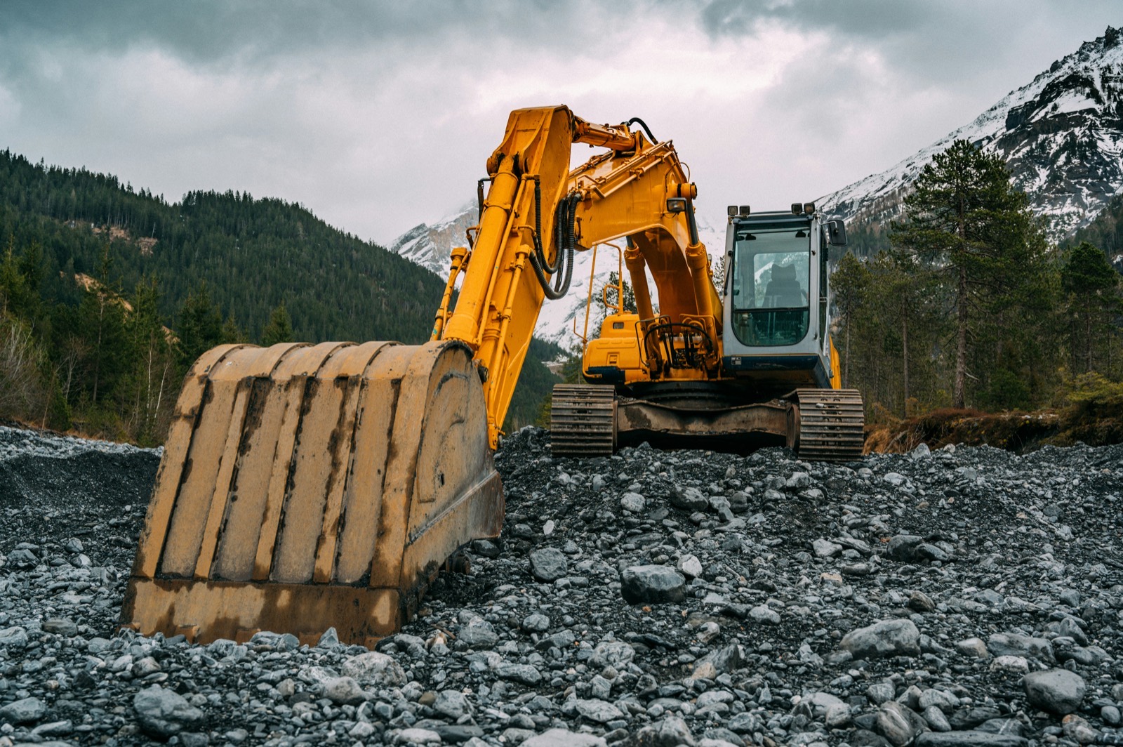 Excavator parked on rocky ground at a remote site