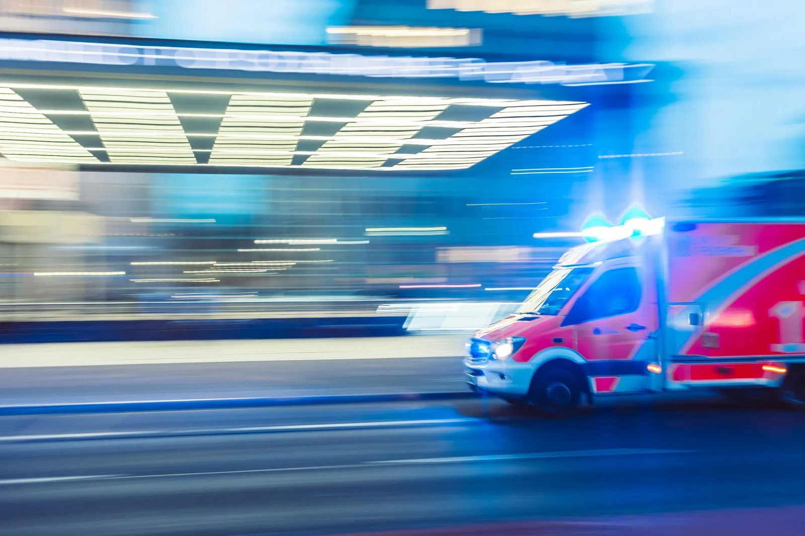 An ambulance running lights through traffic