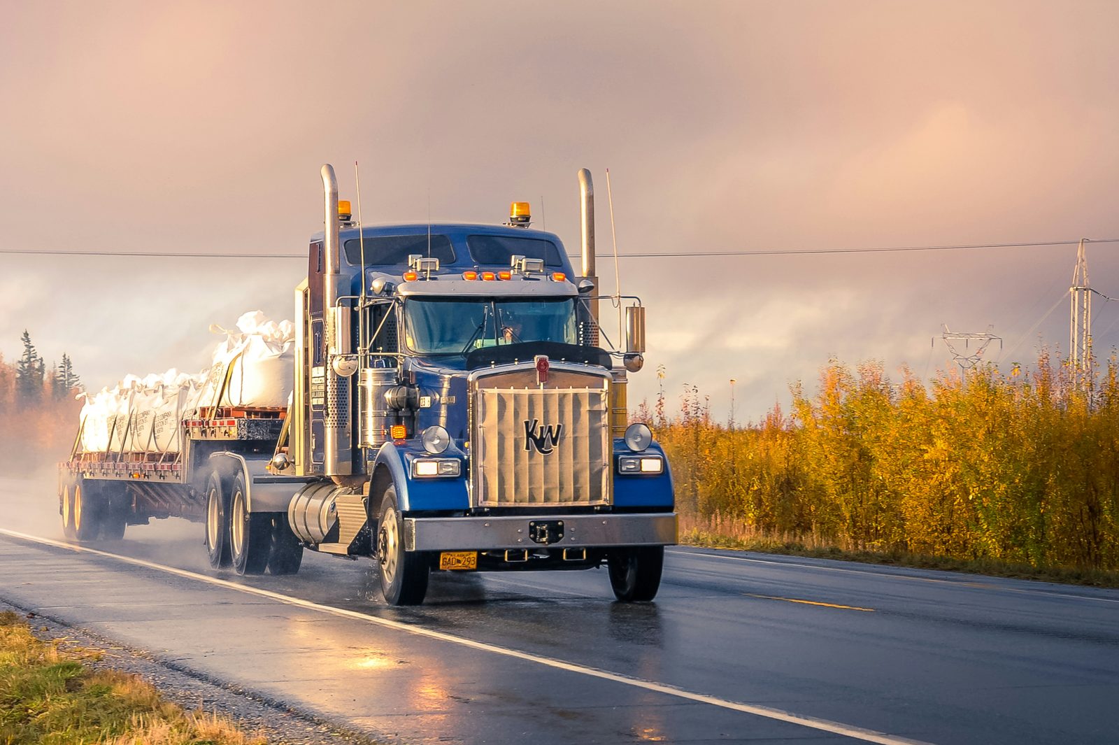A tractor unit on a wet highway at dusk