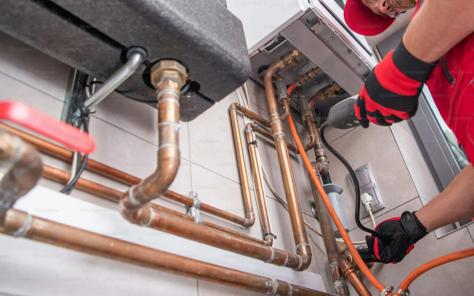 A service technician working on pipework at a customer site