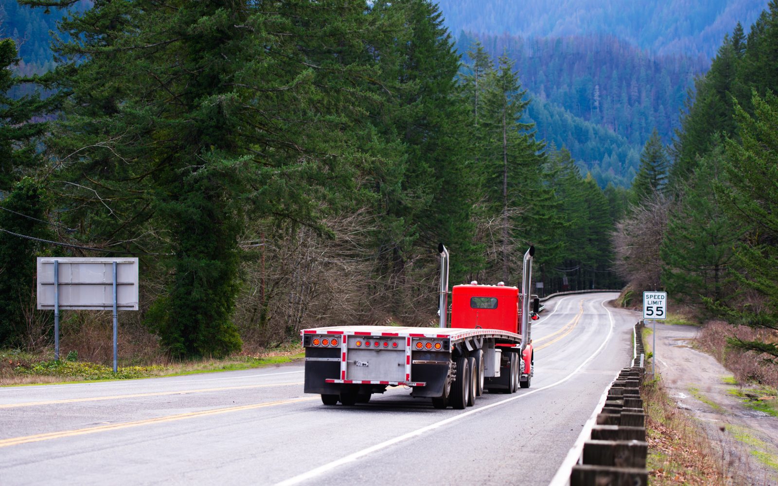 A flatbed trailer on a rural highway